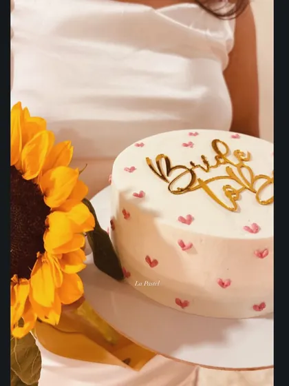A lovely little cake for the 'Bride to Be', decorated with tiny pink hearts and a gold topper. It's the perfect sweet treat for a bachelorette party.