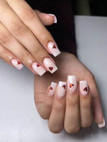 Soft, sweet, and a touch of romance. These milky white, square-shaped nails feature delicate red foil hearts for a clean and modern take on heart nails.