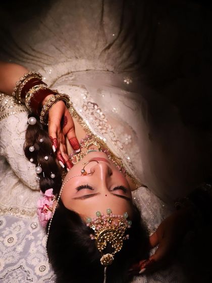 A dramatic, artistic shot that highlights the intricate jewelry and flawless makeup of the bride.