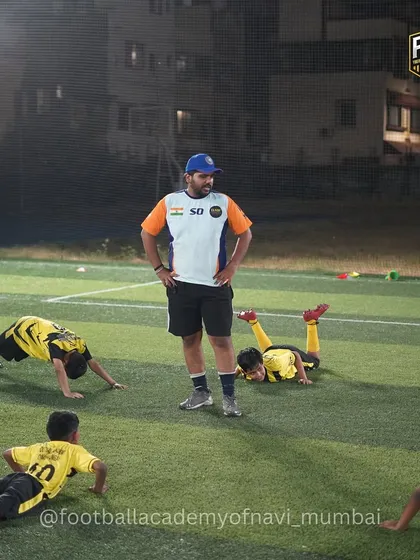 Core strength is crucial for a footballer. Our coach supervises a plank exercise to build physical resilience in our young athletes.