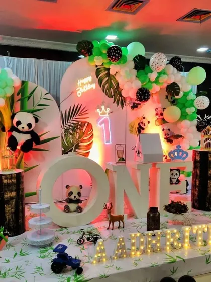 A delightful panda-themed party, a unique take on the jungle theme. The setup includes multiple panda cutouts, bamboo-themed flooring, and large 'ONE' letters with a panda sitting inside.