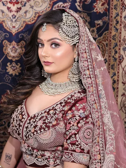 This bride is wearing a beautiful maroon lehenga with silver work. I matched the makeup with a cool-toned smokey eye and a soft pink lip.