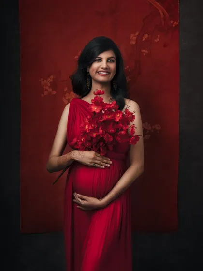 A vibrant and joyful portrait. The bold red dress and matching flowers create a stunning visual, while her smile radiates pure happiness.