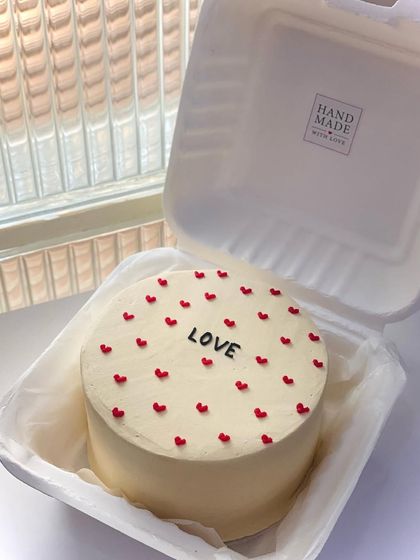 A simple and classic Valentine's Day bento cake with the word 'LOVE' surrounded by tiny red hearts. Sometimes, less is more.