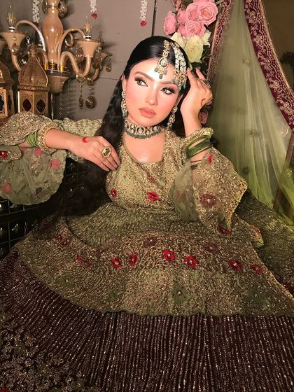 A close-up showcasing the elegant side pose and the intricate details of the outfit. The makeup features a soft contour and a warm, glowing highlight.