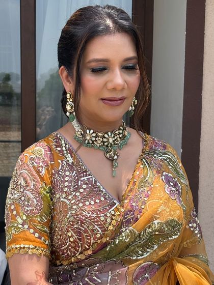 A close-up of the client's face, with the soft, braided front of her hairstyle visible.