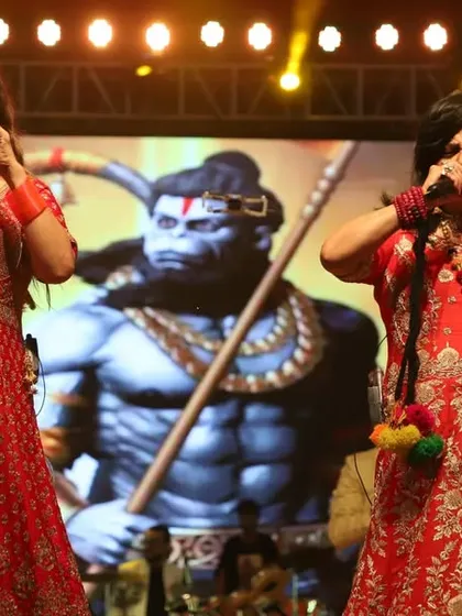Performing in vibrant red outfits, with a powerful image of Lord Hanuman behind us. We often incorporate spiritual elements into our festive shows.