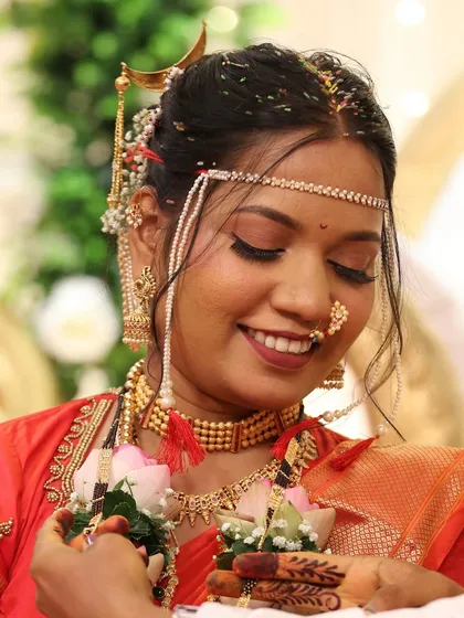 Another joyful, eyes-closed smile. This photo perfectly captures the bride's happiness and the beauty of her traditional red saree look.