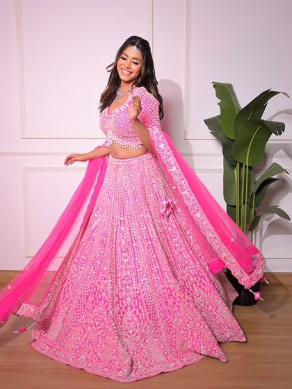 See the beautiful flare of our bright pink lehenga. The flowing dupatta adds a touch of grace to this dazzling and playful outfit.