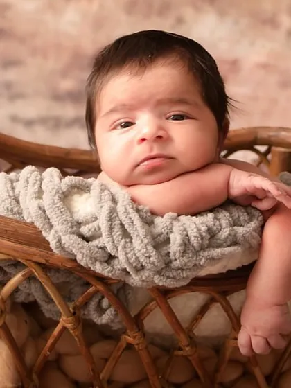 A close-up of this adorable newborn, capturing his thoughtful expression and tiny features. These are the details you will want to remember forever.