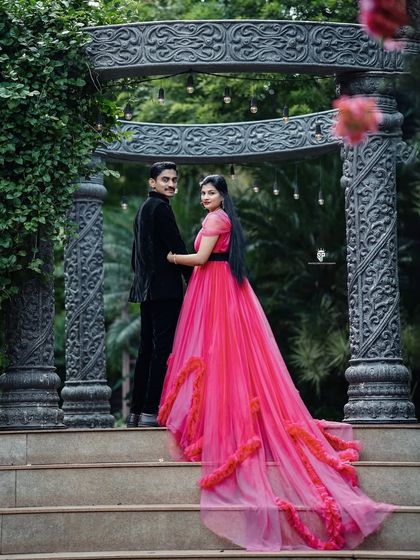 A classic "look back" pose. The long, ruffled train of the magenta gown creates a beautiful line as it cascades down the steps.