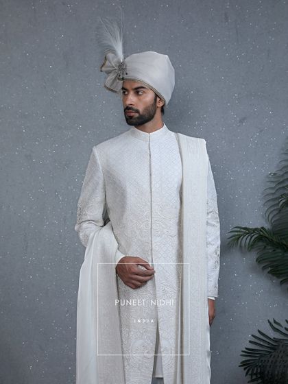 A creation where artistry meets royalty. This ivory sherwani features intricate embroidery and delicate beads, while the pleated stole drapes the timeless grace of tradition.