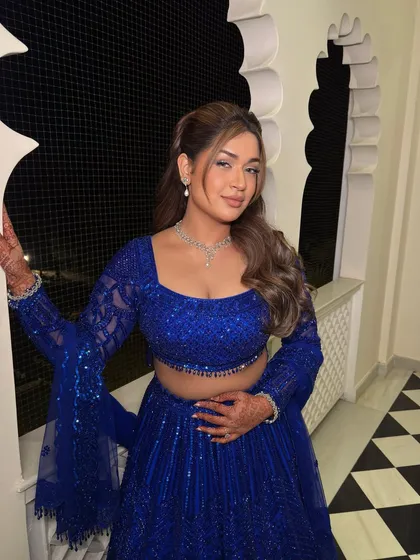 A playful pose showing off the beautiful blue outfit and the soft, glamorous makeup that feels effortlessly her.