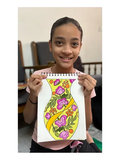 A student with her floral vase design for the intermediate grade exam. The bright, cheerful colours and flowing patterns make this a lovely piece.