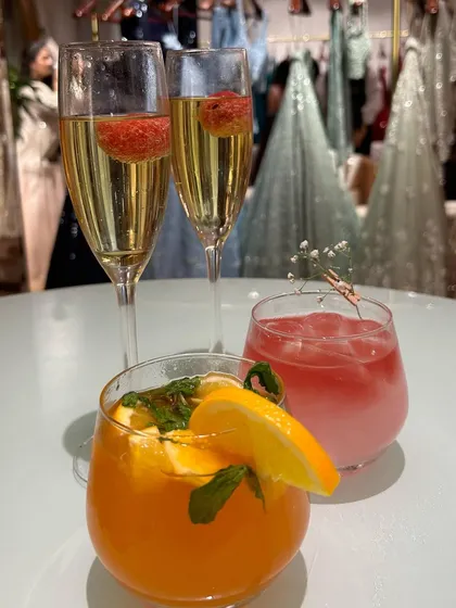 A trio of our custom creations: sparkling champagne with raspberries, a vibrant orange and mint mocktail, and a delicate pink gin drink. There's something for every palate.