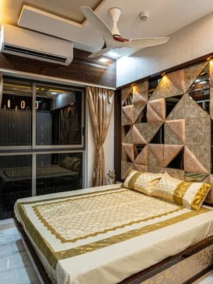 This bedroom at Lodha Belair uses a geometric, cushioned headboard with alternating textures and mirror inserts. The design creates a dynamic and modern feature wall that serves as the room's centerpiece.
