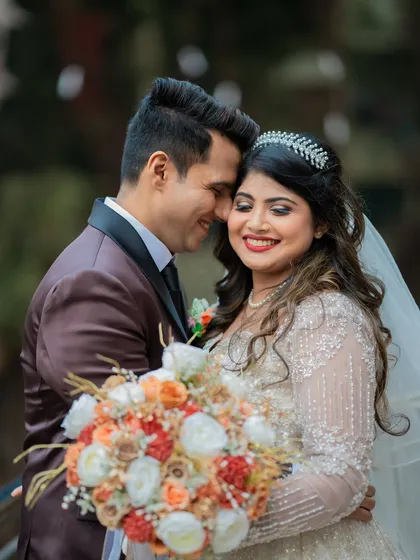 A close-up of the happy Catholic couple, showing the bride's beautiful bouquet and the groom's affectionate embrace.