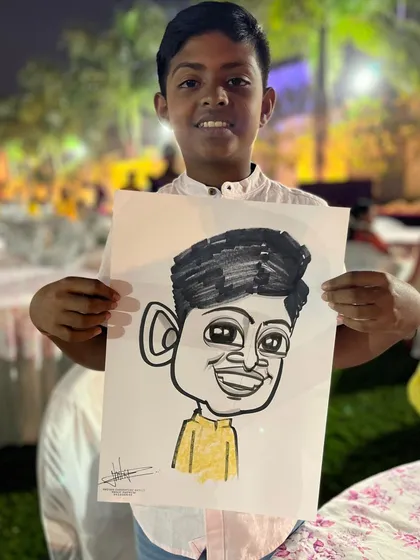 A young boy happy with his caricature at the wedding in Ambegaon. It's a great way to keep younger guests entertained.
