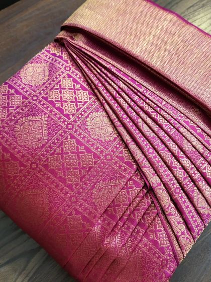 A rich magenta Kanjivaram saree pre-pleated for a Sri Lankan bride's wedding.