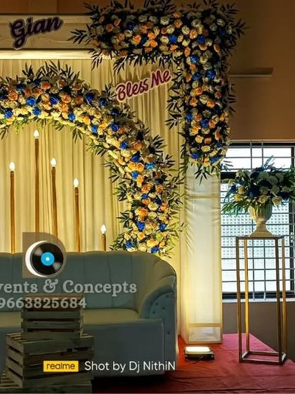 An elegant cradling ceremony stage with a floral arch and personalized name signs. The clean design and classic blue and yellow color scheme create a joyful and welcoming setting.