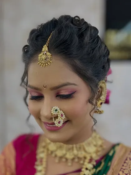 A close-up of a traditional Maharashtrian bridal look, focusing on the detailed eye makeup and classic jewelry like the nath.