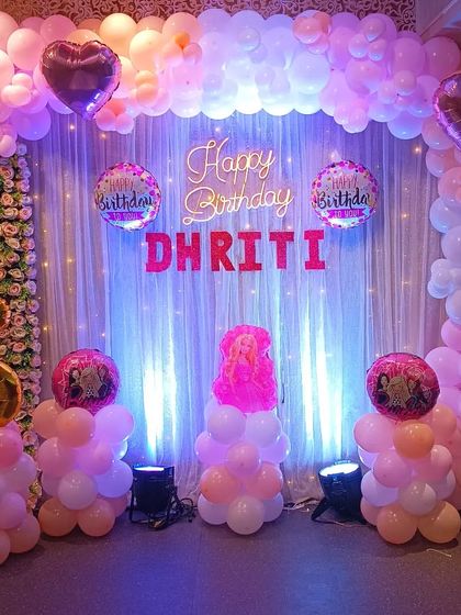 A classic pink and white balloon backdrop for a 6th birthday, complete with a neon sign and foil balloons.