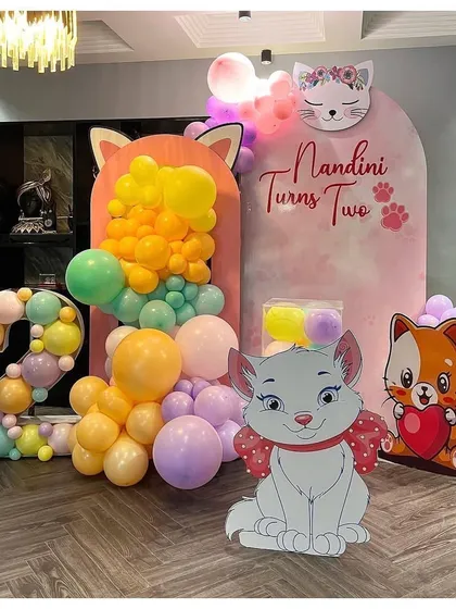 A sweet Marie Cat theme for a second birthday. I used pastel balloons, cat-themed backdrops, and a large number '2' made of balloons.