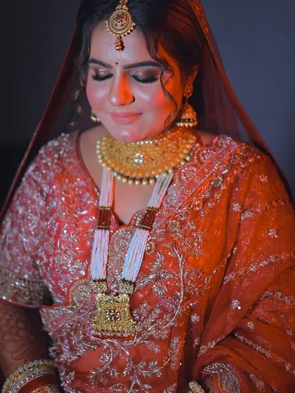 A beautifully lit portrait with warm tones, highlighting the golden jewelry and rich fabric of the bridal wear.