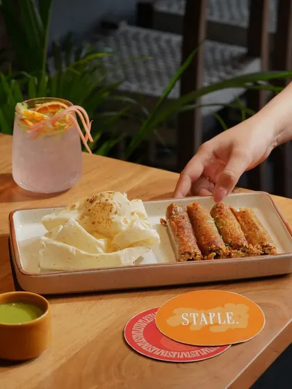 A plate of seekh kebabs with a side of malai, paired with a refreshing cooler, showcasing a classic appetizer.