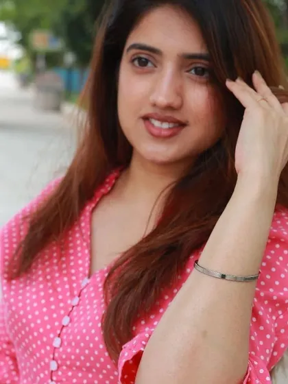 A woman in a pink polka-dot shirt adjusts her silver cuff, which can be engraved with any inspirational quote you choose.