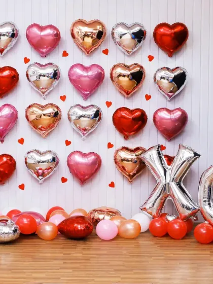 A wall of love for Valentine's Day or an anniversary. This decoration features a grid of heart-shaped foil balloons in red, pink, and silver, with large 'XO' letters.