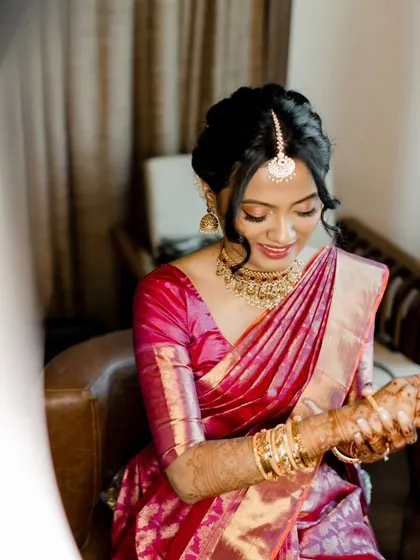 A series of photos capturing the grace of this South Indian bride. Her look features traditional temple jewelry, a silk saree, and a fresh, dewy makeup finish with a classic floral hair bun, embodying timeless elegance.