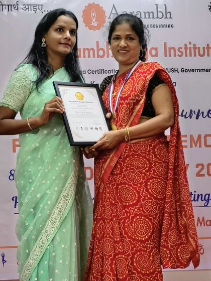 A student proudly holds her certificate, a symbol of her commitment to the path of yoga and her readiness to share its teachings.