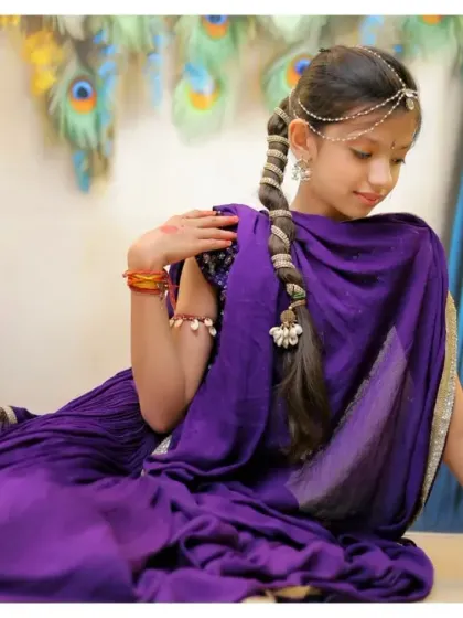 A beautiful, flowing pose in a purple saree for a Radha Rani shoot. We guide children into poses that are both natural and photogenic.