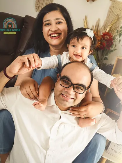 A fun and energetic family portrait. The joy is contagious in this photo of a baby enjoying a shoulder ride from dad.
