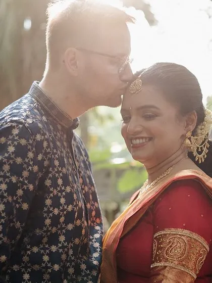 A tender forehead kiss, with the sun creating a beautiful flare behind the couple, highlighting the romance of the moment.