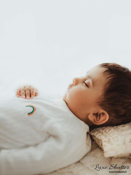 A peaceful profile shot of a five-month-old baby sleeping. Even at this age, we can capture those quiet, angelic moments.