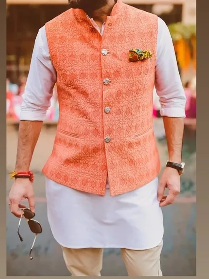 A great example of a modern ethnic look. I tailored this peach-colored Nehru jacket with a subtle woven pattern to be worn over a simple white kurta for a fresh, stylish outfit.