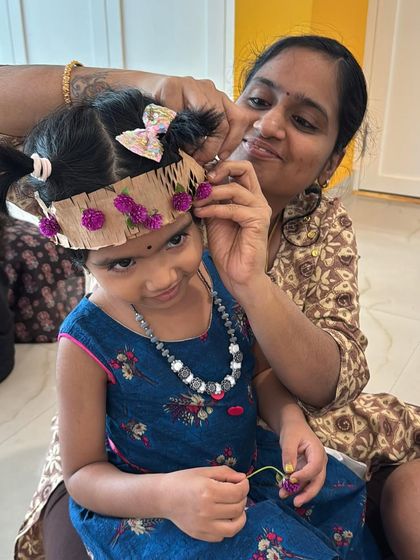 A mother gently helps her daughter adjust her handmade flower crown. These moments of shared creation are what make the workshops so meaningful for families.
