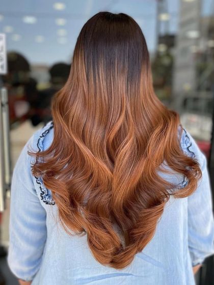 I call this look 'Santa Fe' for its warm, earthy, and vibrant tones. This copper-brown balayage on long, flowing hair creates a masterpiece of color that is both bold and beautiful.