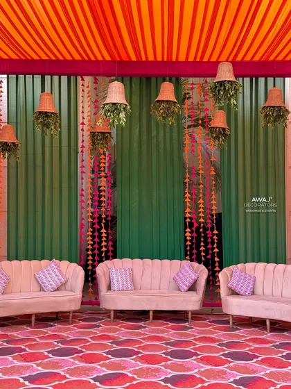 The main seating area for the Mehendi, with comfortable sofas set against a backdrop of colorful drapes and a patterned floor.