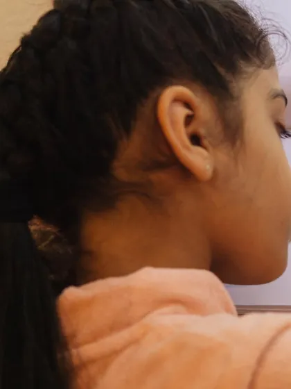 Samara, seen from the side, is completely absorbed in her drawing. This is the kind of deep engagement we aim to foster in all our creative activities.