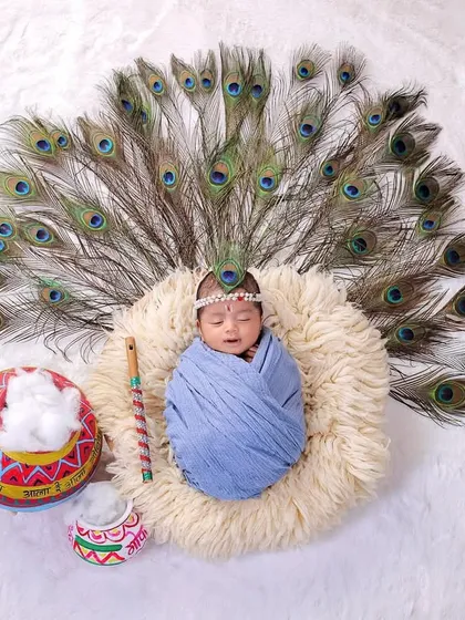 A newborn version of our Little Krishna theme. Here, the baby is safely swaddled and surrounded by a fan of peacock feathers, creating a stunning and symbolic portrait.