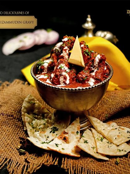 Indulge in the deliciousness of our Chicken Nizamuddin Gravy. This dish features tender chicken in a rich, spicy, and aromatic gravy, perfect with a piece of fresh naan.