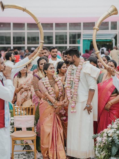 The couple stands together during their ceremony, framed by traditional horn blowers, a moment of regal beauty.