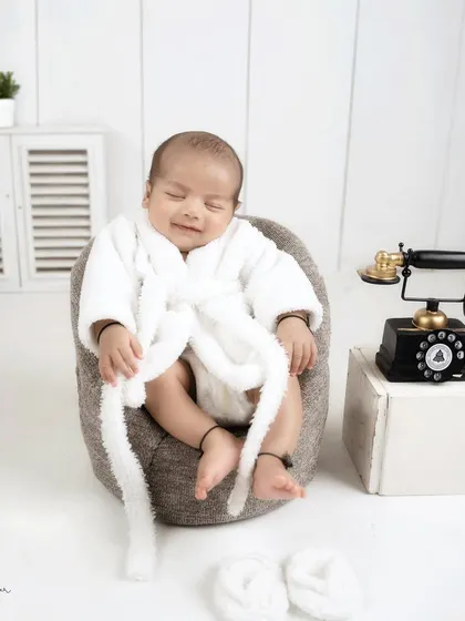 The 'Boss Baby' is taking a well-deserved break. This funny and cute shot shows the baby relaxing in a mini armchair with a content smile.
