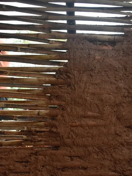 Here you can see the Wattle and Daub technique in progress. A lattice of bamboo is daubed with a mix of local clay and natural fibers, creating a strong and insulating wall using ancient methods.