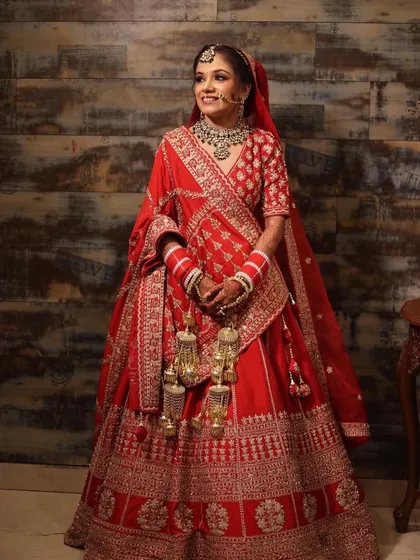 A pretty bride in a classic red lehenga, wearing a kundan and emerald set. Her kaleeras and chooda are also from my collection.