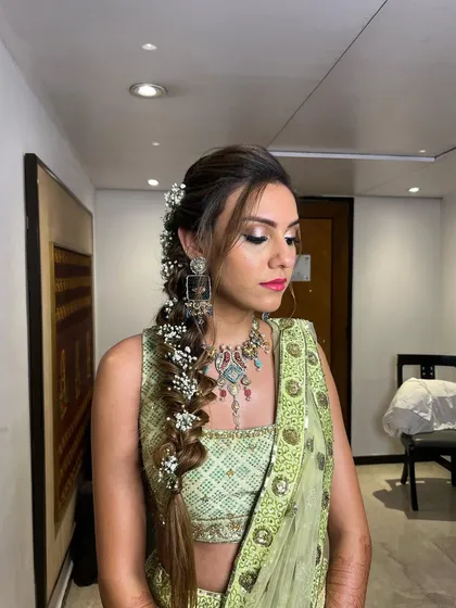A soft and romantic fishtail braid for a Mehendi look, woven with delicate baby's breath for a dreamy, bohemian vibe.