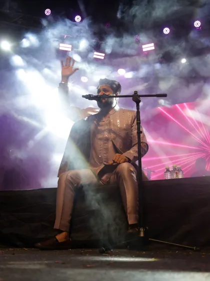 Taking a moment to connect with the audience, sitting on the edge of the stage. It's all about creating an intimate vibe, even in a large venue.